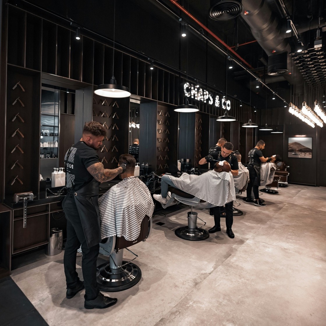 Barbers at work inside the Chaps & Co barbershop.